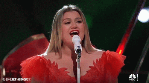 Woman In Red Dress Singing Into Microphone GIF