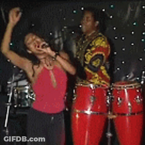 Woman In Red Dress Singing Into Microphone On Stage GIF