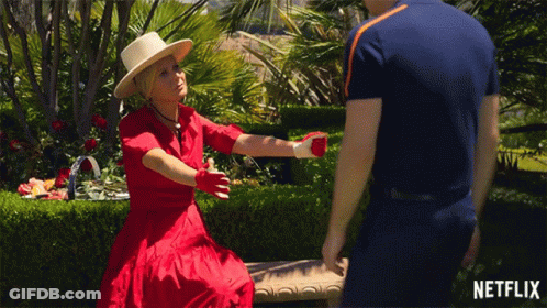 Woman In Red Dress Sitting On Bench Talking To Man GIF