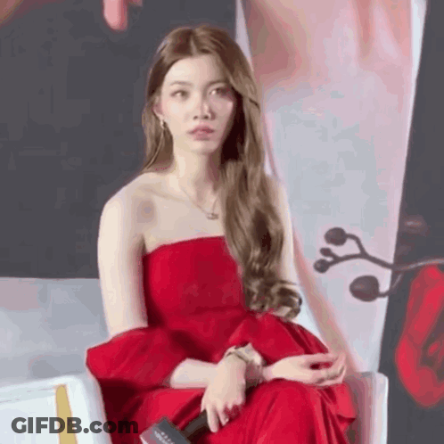 Woman In Red Dress Sitting With Microphone GIF