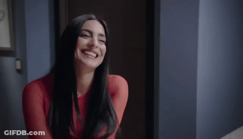 Woman In Red Dress Smiling And Laughing In Hallway GIF