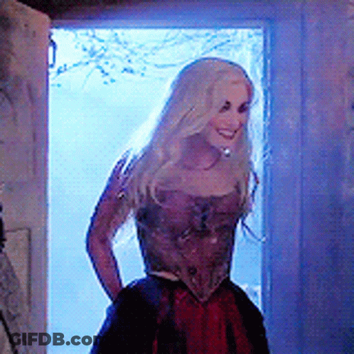 Woman In Red Dress Smiling In Doorway GIF