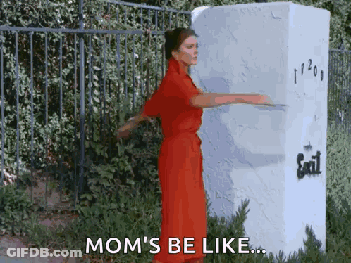 Woman In Red Dress Standing In Front Of Exit Sign GIF