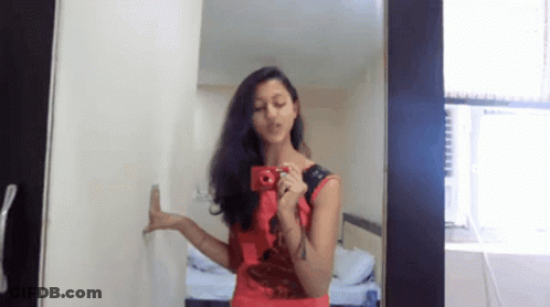 Woman In Red Dress Taking Mirror Selfie GIF