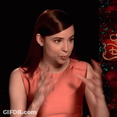 Woman In Red Dress Talking At Disney Sign GIF
