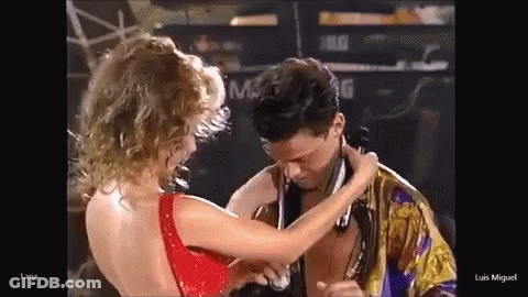 Woman In Red Dress Touching Man's Neck GIF