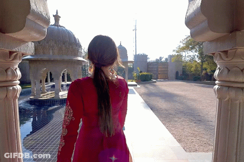Woman In Red Dress Walking By Building GIF