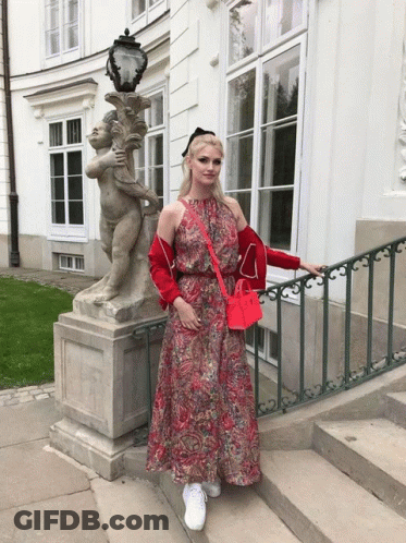 Woman In Red Dress With Cherub Statue GIF
