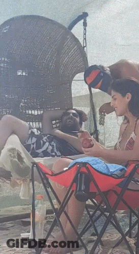 Woman In Red Folding Chair Beside Man GIF