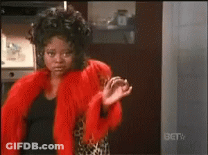Woman In Red Fur Coat Standing In Front Of BET TV Sign GIF