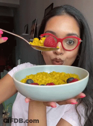 Woman In Red Glasses Holding Bowl Of Oatmeal With Berries GIF