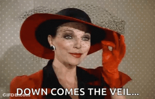Woman In Red Hat And Gloves Says Down Comes The Veil GIF