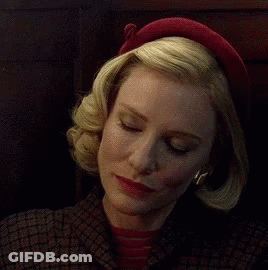 Woman In Red Hat And Plaid Jacket Looking At Camera GIF