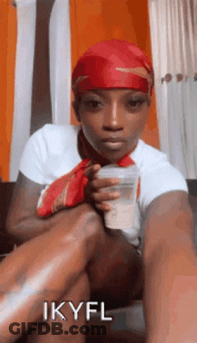 Woman In Red Headband Sitting On Couch Holding Cup GIF