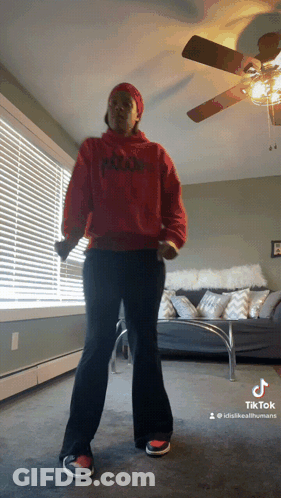 Woman In Red Hoodie Dancing In Living Room With Ceiling Fan GIF