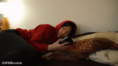 Woman In Red Hoodie On Phone In Bed GIF