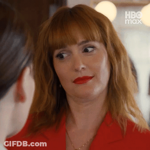 Woman In Red Jacket And Red Lipstick Looking At Woman GIF