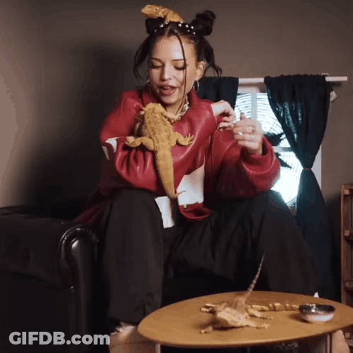 Woman In Red Jacket Holding Lizard GIF
