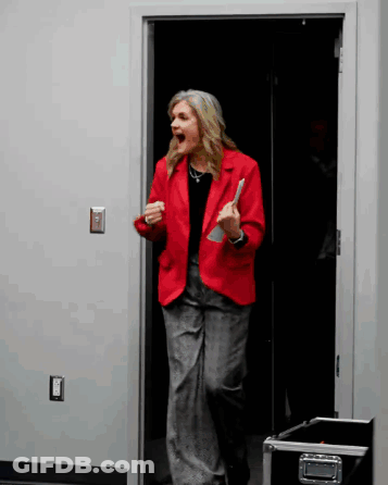 Woman In Red Jacket In Doorway Mouth Open GIF