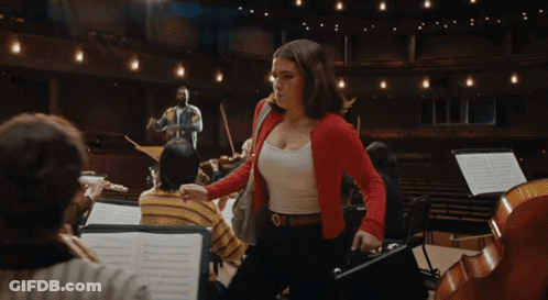 Woman In Red Jacket In Front Of Orchestra GIF