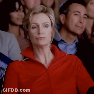 Woman In Red Jacket Sitting In Crowd GIF