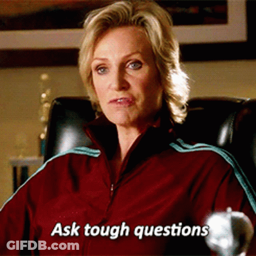 Woman In Red Jacket Sitting With Text Ask Tough Questions GIF