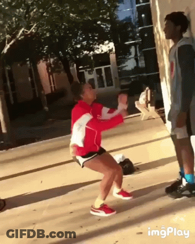 Woman In Red Jacket Squatting On Sidewalk GIF