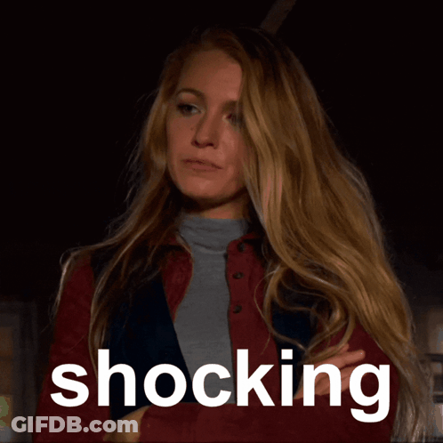 Woman In Red Jacket Standing Before Shocking Sign GIF