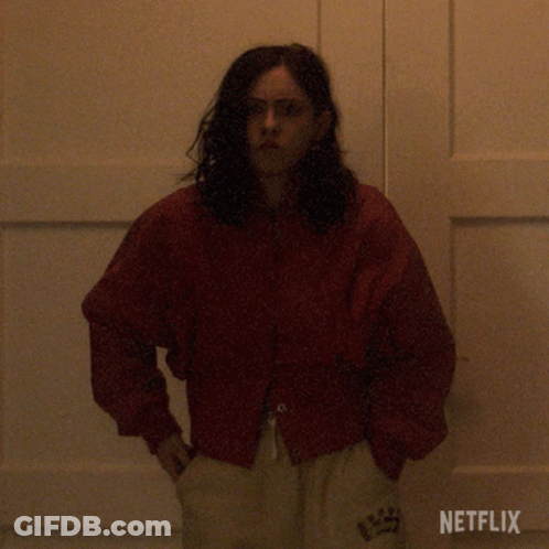 Woman In Red Jacket Standing By Netflix Door GIF