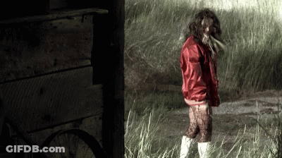 Woman In Red Jacket Standing In Grass GIF