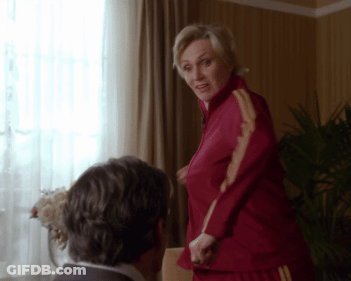 Woman In Red Jacket With Yellow Stripes Next To Man In Suit GIF