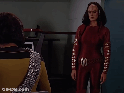 Woman In Red Jumpsuit And Man Saying You Are Late GIF