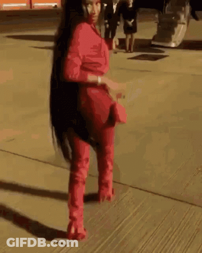 Woman In Red Jumpsuit And Red Boots Walking GIF