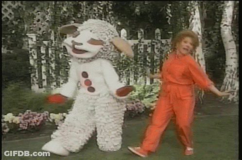 Woman In Red Jumpsuit Dancing Beside Sheep Mascot GIF