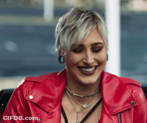 Woman In Red Leather Jacket With Faith Necklace Smiling GIF