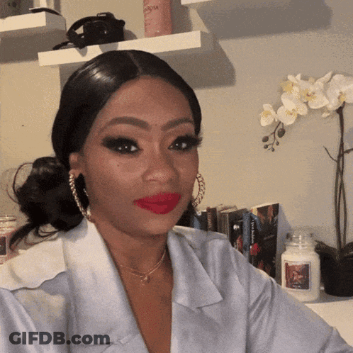 Woman In Red Lipstick And Hoop Earrings Sitting By Candle GIF