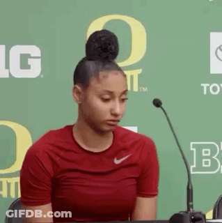 Woman In Red Nike Shirt Sitting At Microphone GIF