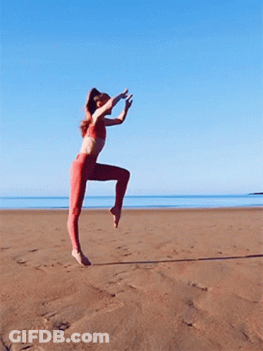 Woman In Red Pants Jumping On Beach GIF