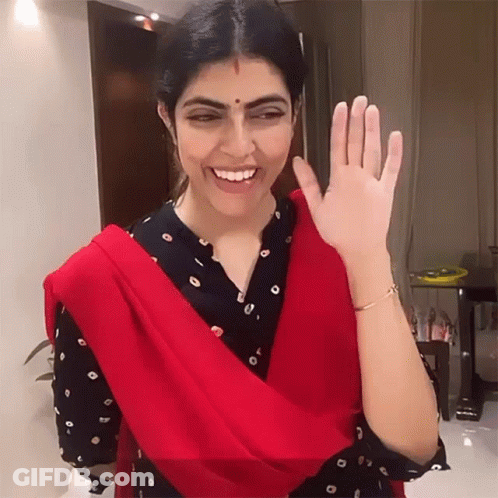 Woman In Red Scarf Smiling And Waving GIF
