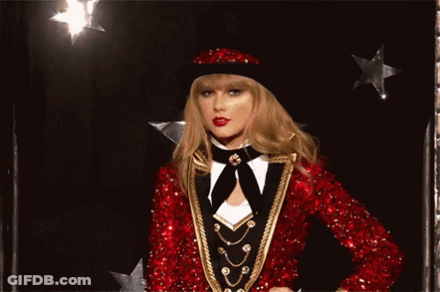 Woman In Red Sequined Jacket And Hat Winking GIF