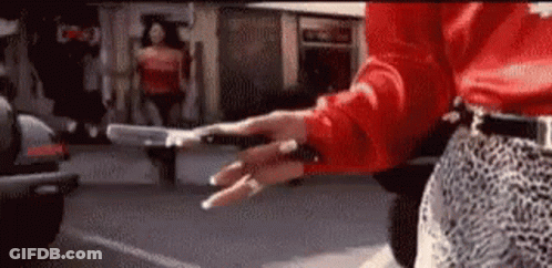 Woman In Red Shirt And Leopard Skirt Holding Gun GIF