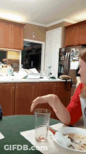Woman In Red Shirt At Table With Plate And Glass GIF