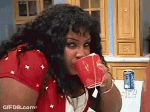 Woman In Red Shirt Drinking From Red Cup GIF
