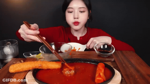 Woman In Red Shirt Eating With Chopsticks And Spoon GIF