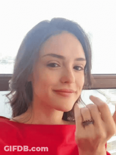 Woman In Red Shirt Looking At Camera GIF