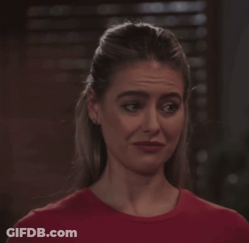 Woman In Red Shirt Looking At Camera GIF