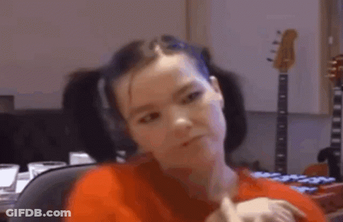 Woman In Red Shirt Sitting In Front Of Guitar GIF