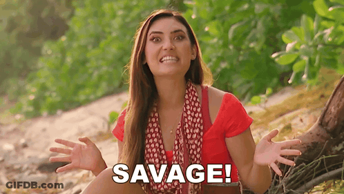 Woman In Red Shirt Sitting On Beach With Hands Outstretched Saying Savage GIF