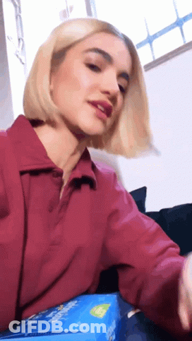 Woman In Red Shirt Sitting On Couch With Candy GIF