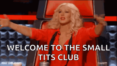 Woman In Red Shirt Sitting With Arms Outstretched Welcome To The Small Tits Club GIF
